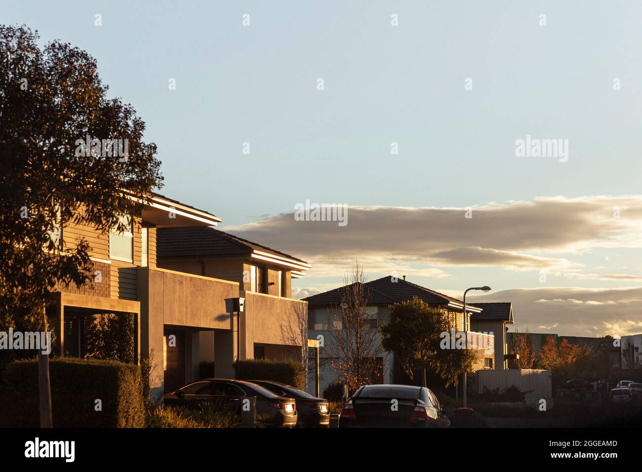 Parking dans la rue avec maisons en rangée d'appartements au ciel clair. Banque D'Images