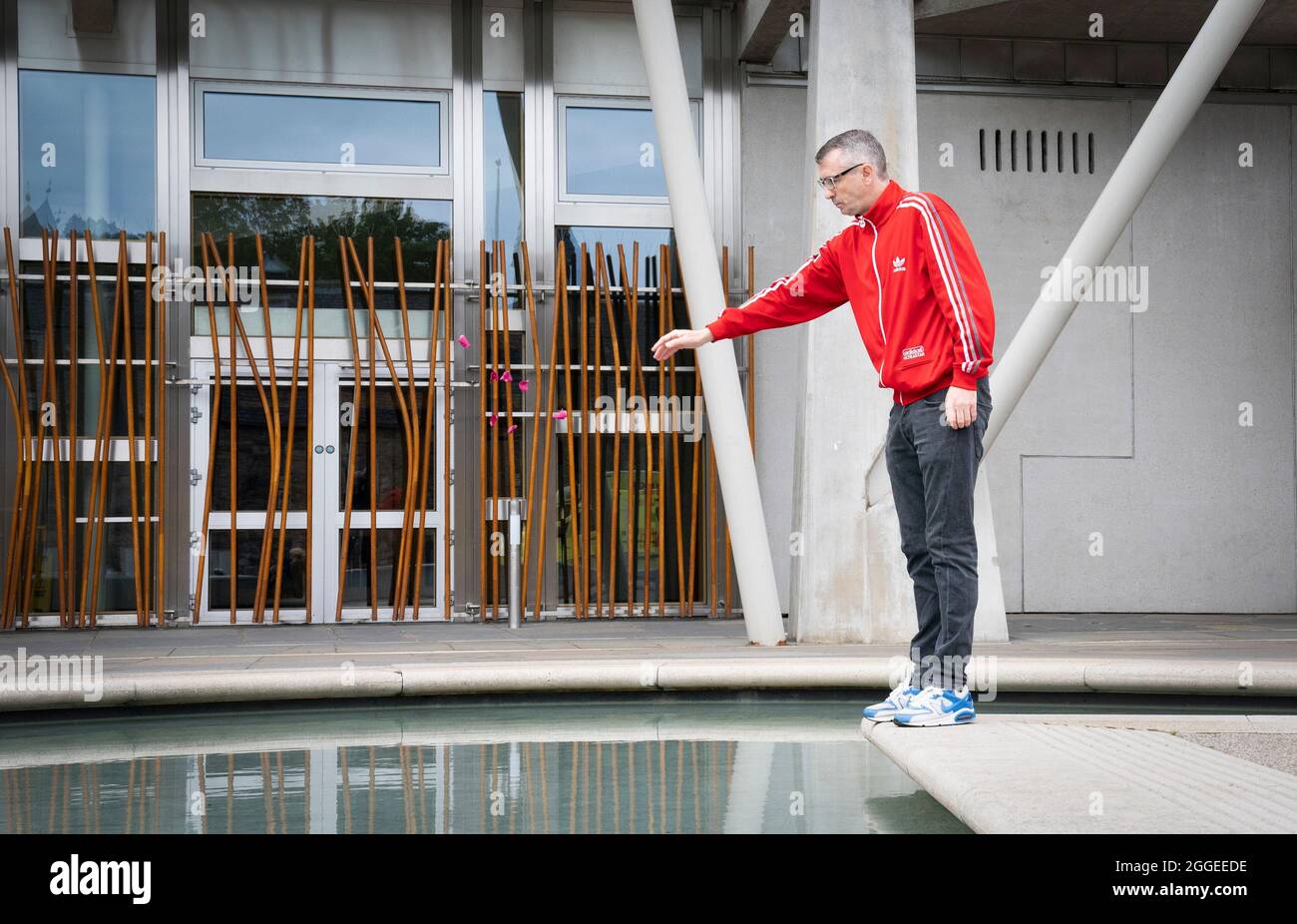 Peter Krykant jette des pétales de fleur dans les piscines à l'extérieur du Parlement écossais, à Édimbourg, lors d'une cérémonie marquant la Journée internationale de sensibilisation au surdosage. Date de la photo: Mardi 31 août 2021. Banque D'Images