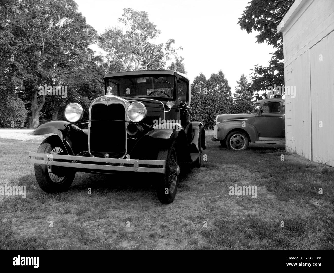 1936 Ford Cabriolet et un pick-up des années 1940 en arrière-plan, États-Unis. Banque D'Images