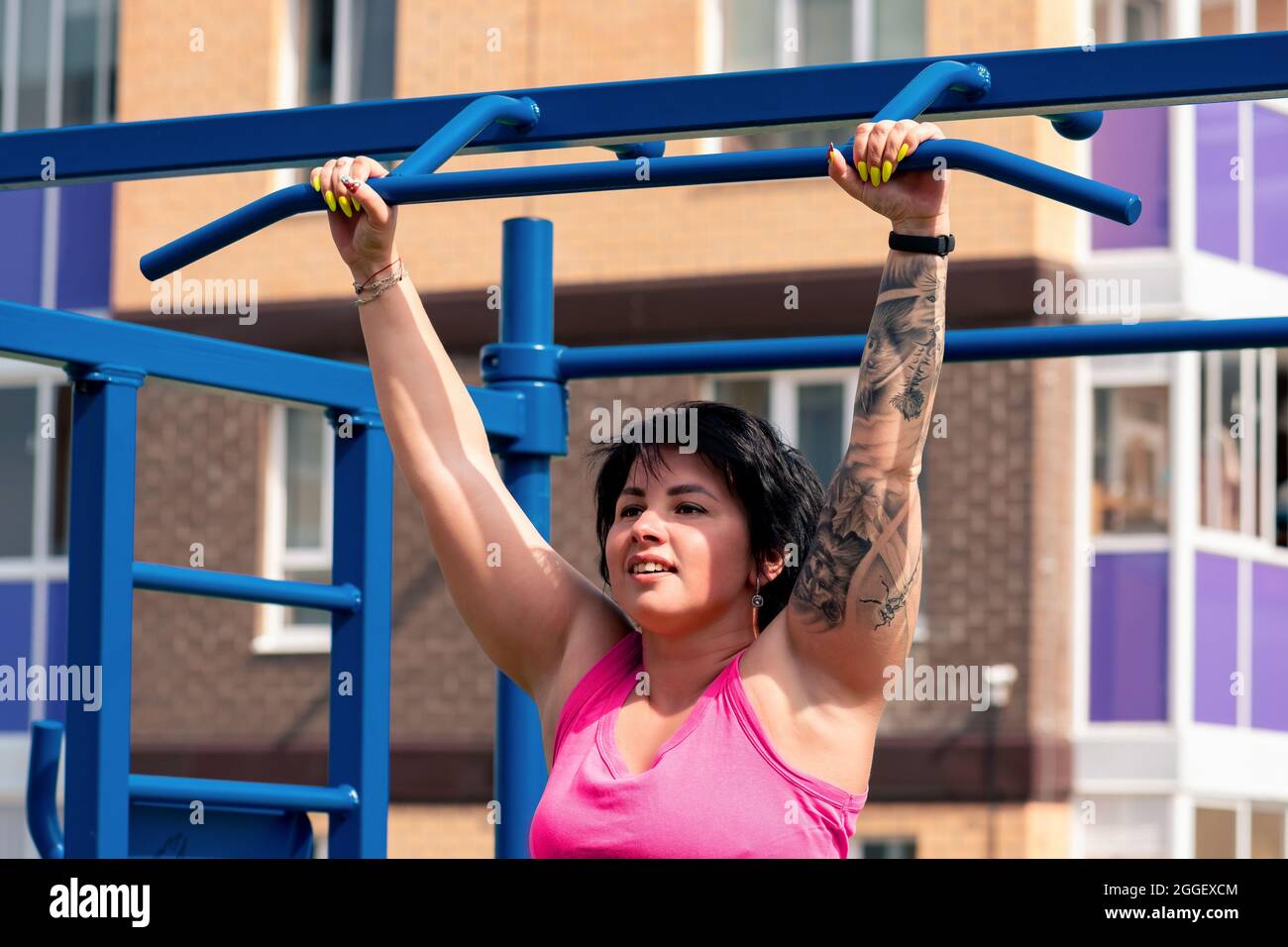 la jeune femme effectue des exercices en plein air en utilisant la barre horizontale de la rue Banque D'Images