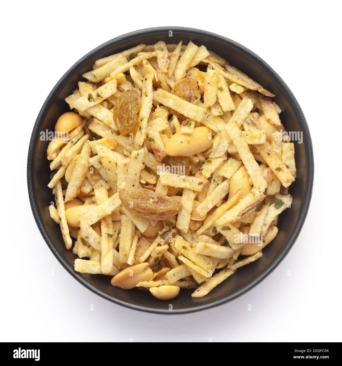 Gros plan du mélange Aloo dans un bol en céramique noire à base de pommes de terre, d'arachides et de raisins secs. En-cas indiens épicés (Namkeen), vue de dessus Banque D'Images