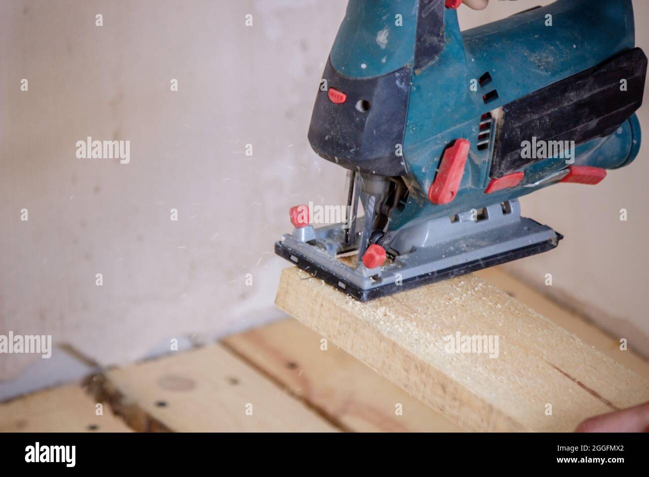 Un homme coupe une planche avec une scie électrique. Réparation du plancher dans la maison. Mise au point sélective. Interr Banque D'Images