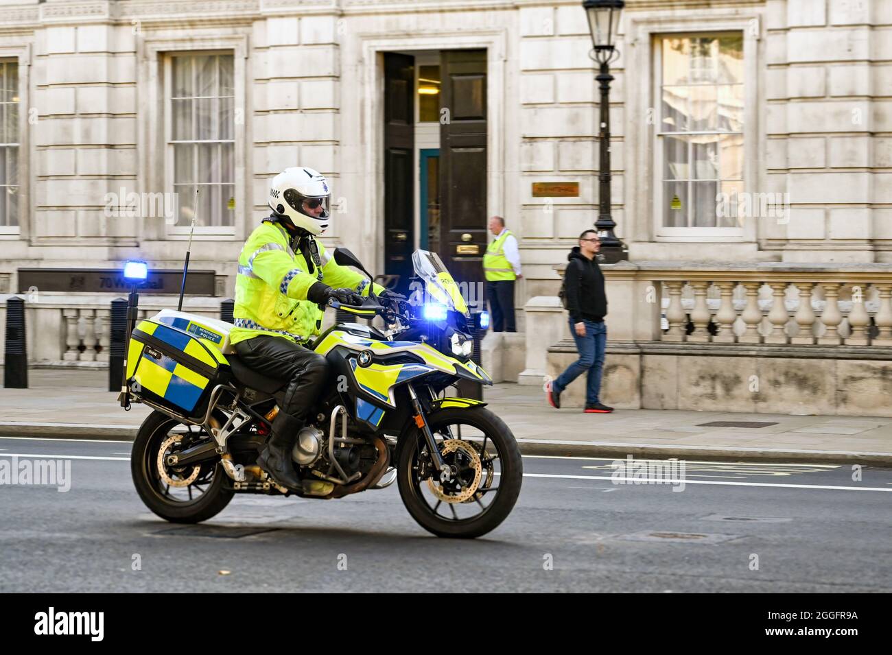 Londres, Angleterre - août 2021 : policier sur une moto avec des feux bleus qui clignotent en descendant une rue dans le centre de Londres Banque D'Images