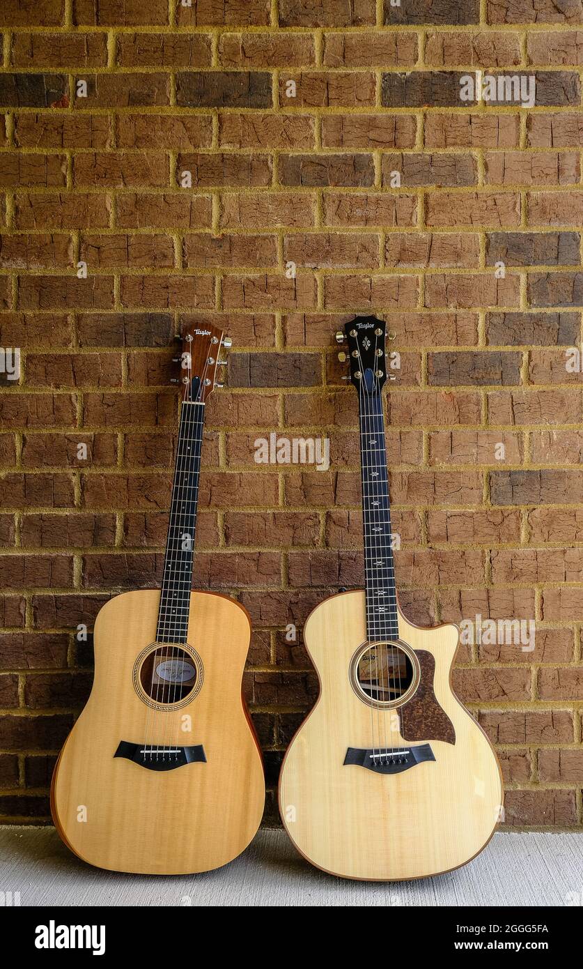 Deux guitares Taylor sur le mur de briques Banque D'Images