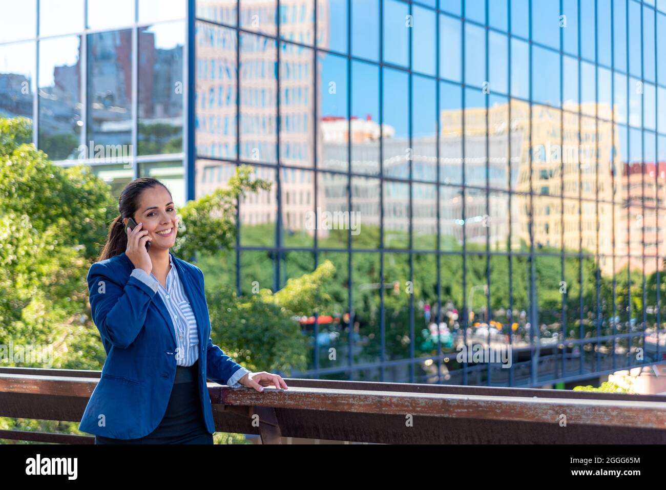 Femme d'affaires de taille moyenne d'adulte de race blanche avec téléphone mobile dans la ville Banque D'Images