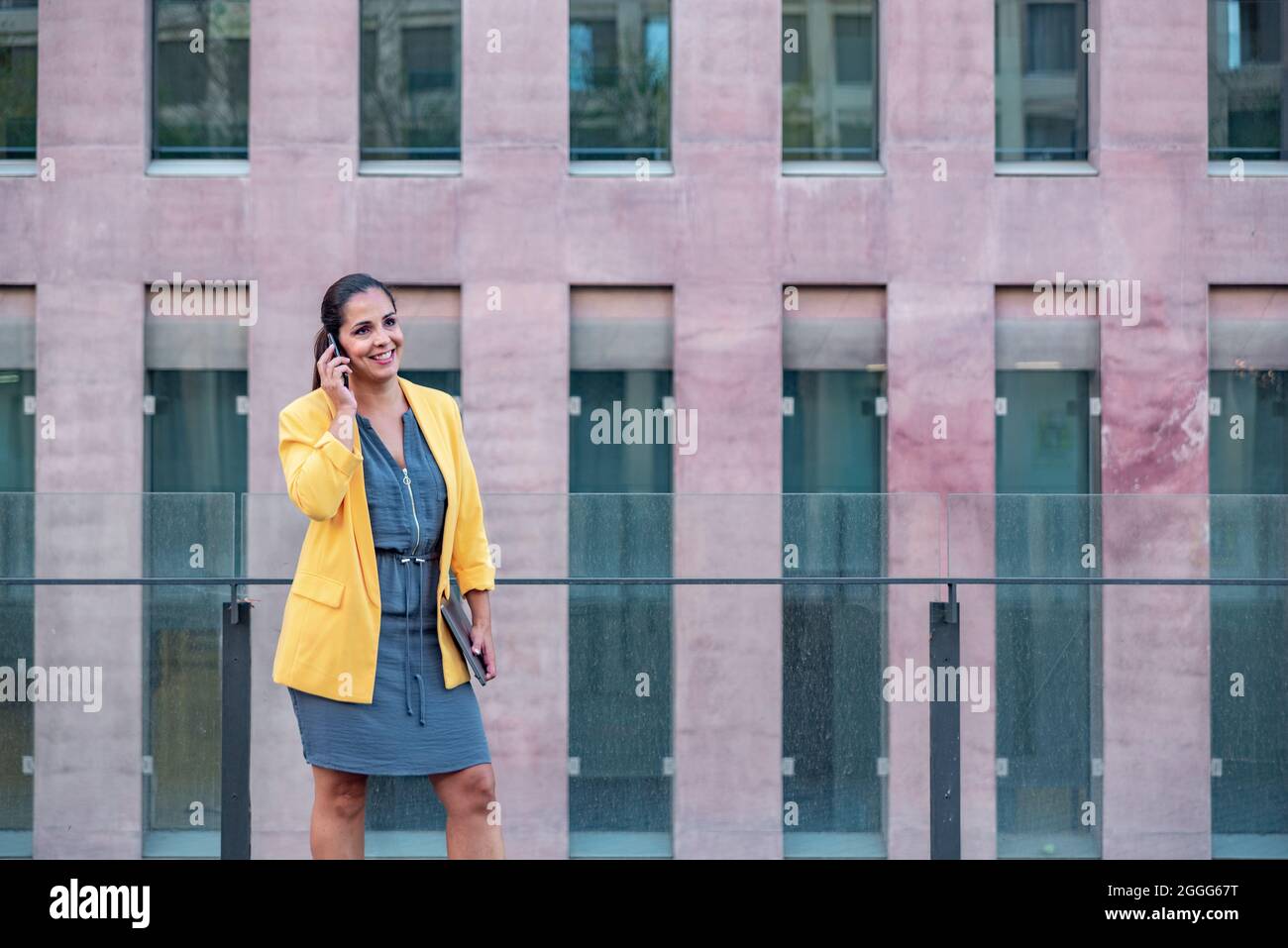 Femme d'affaires caucasienne avec téléphone mobile et ordinateur à l'extérieur. Banque D'Images