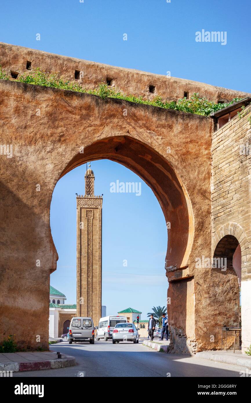 Porte dans le mur de la médina de Rabat et en arrière-plan un minaret et une mosquée typiquement marocaines Banque D'Images