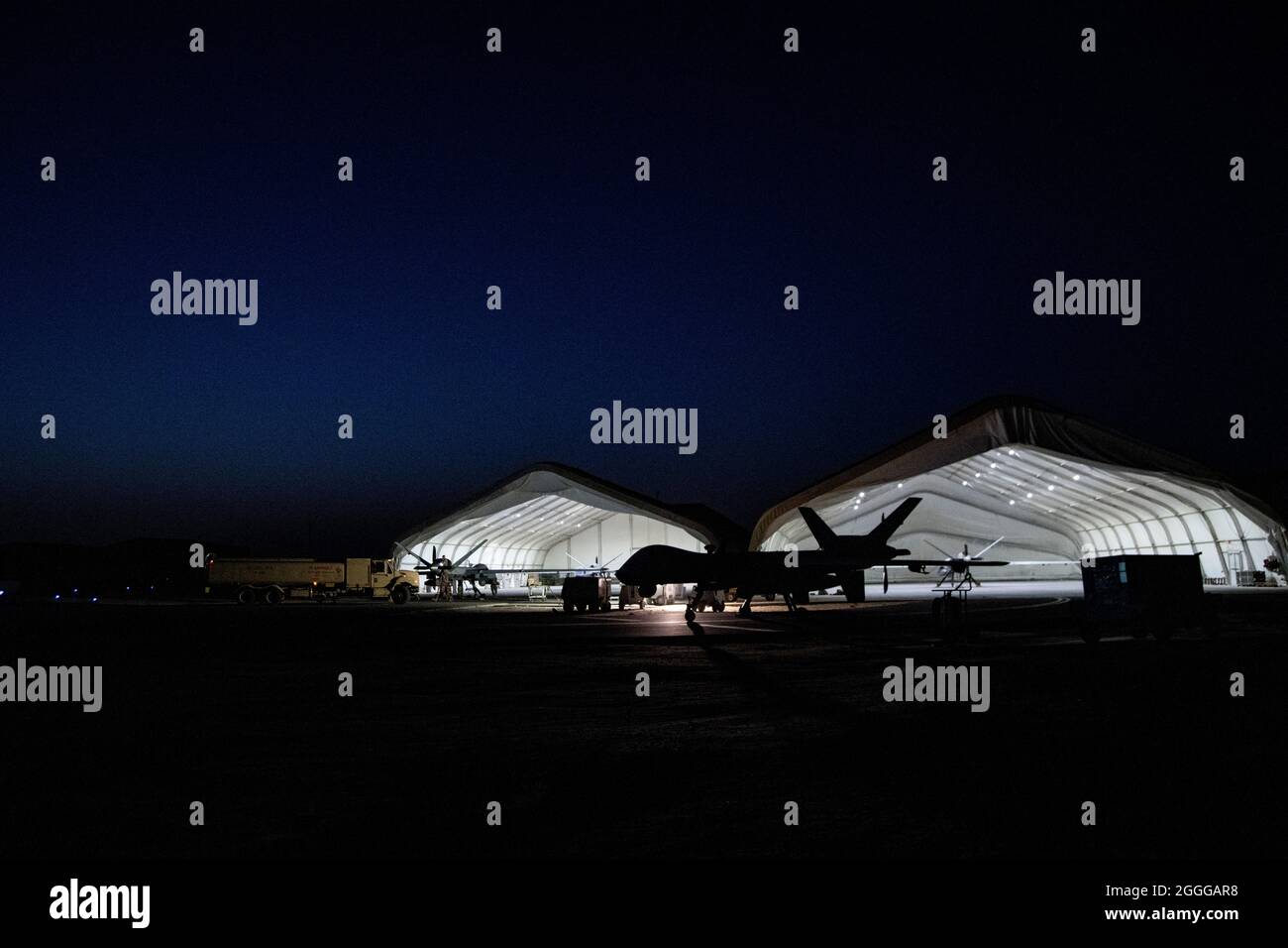 Un véhicule aérien sans pilote MQ-9 Reaper est installé sur la piste de la base aérienne Ali Al Salem, au Koweït, le 10 juin 2020. Un aviateur du 386e Escadron de maintenance d’aéronefs expéditionnaires, autre connu sous le nom de ‘l’UMA blanche’, entretient, prépare et récupère les 9-MQ avant et après chaque lancement, assurant ainsi un succès optimal de la mission. (É.-U. Photo de la Force aérienne par Tech. Sgt. Alexandre Montes) Banque D'Images