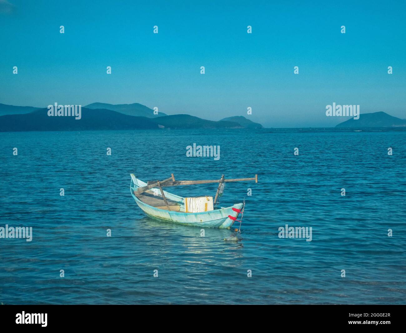 Un petit bateau de pêche est ancré près de la rive dans la baie de Nha Trang, au Vietnam Banque D'Images