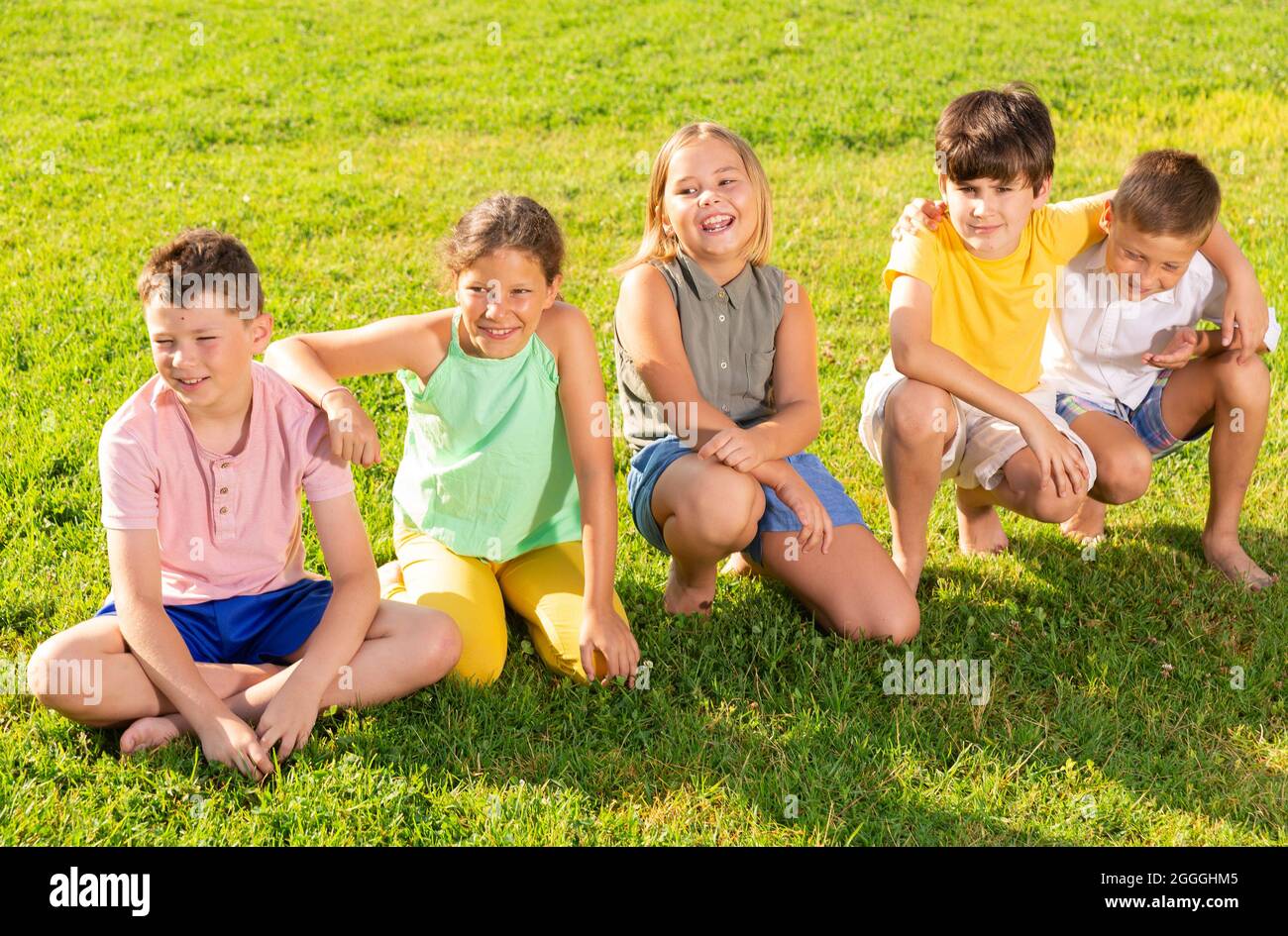 Cinq enfants assis sur l'herbe Banque D'Images