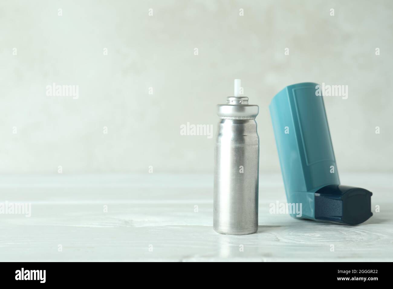 Inhalateur pour asthme bleu sur table en bois blanc Banque D'Images