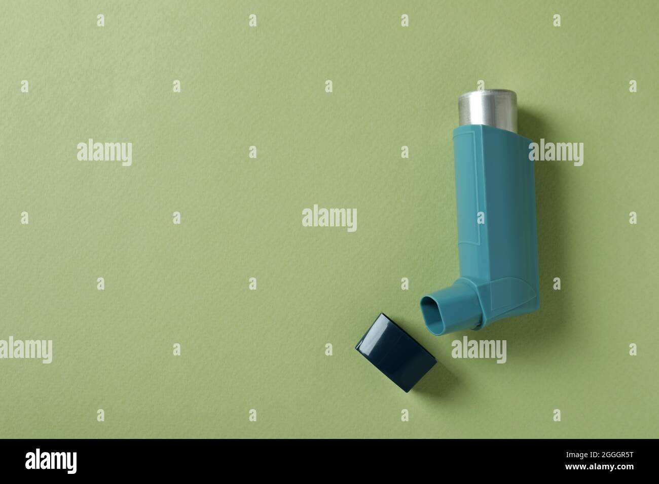 Inhalateur pour asthme bleu sur fond vert, vue du dessus Banque D'Images