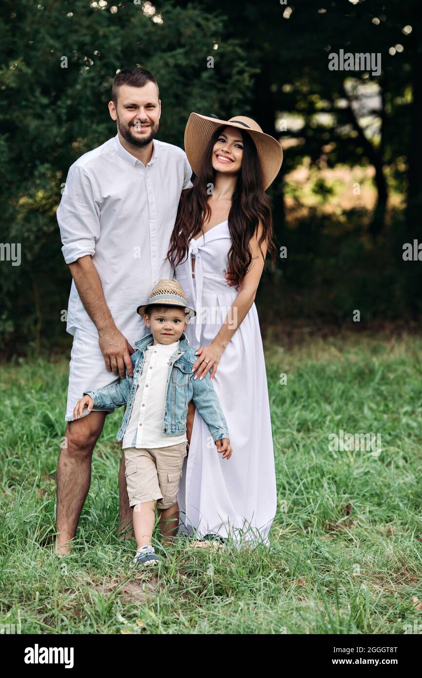 Belle maman, papa et leur petit enfant mignon ont plaisir ensemble et sourires dehors Banque D'Images
