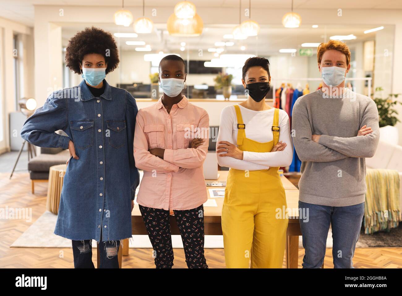 Portrait de divers groupes de créatifs portant des masques au travail, regardant l'appareil photo Banque D'Images