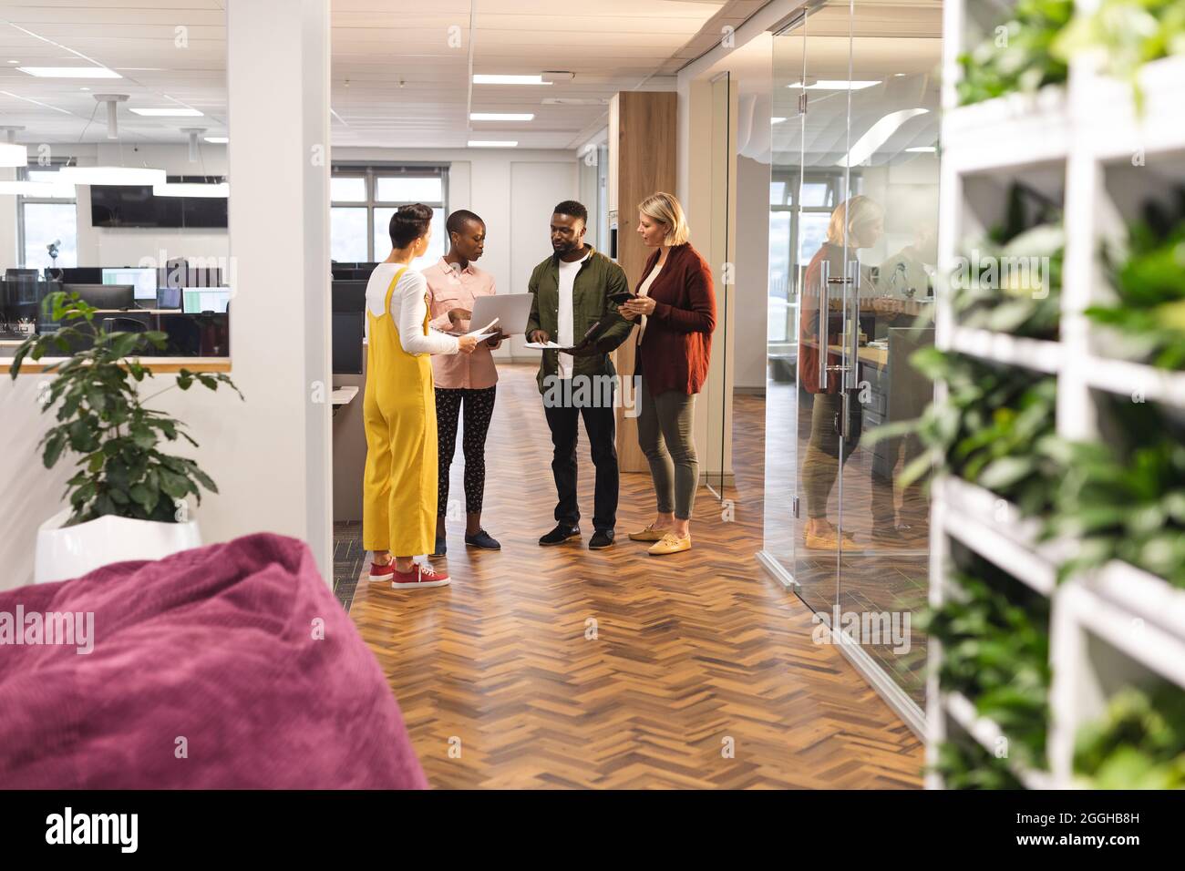 Divers collègues hommes et femmes travaillant ensemble à l'aide d'un ordinateur portable Banque D'Images