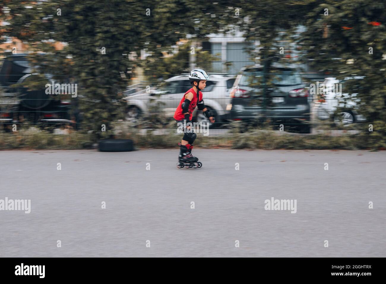 Ukraine, Kiev - 27 juin 2021: Entraînement de garçon pour patins en ligne. Patins en ligne à lames roulante, casque HQBC, protection contre les lames de puissance. Éditorial Banque D'Images