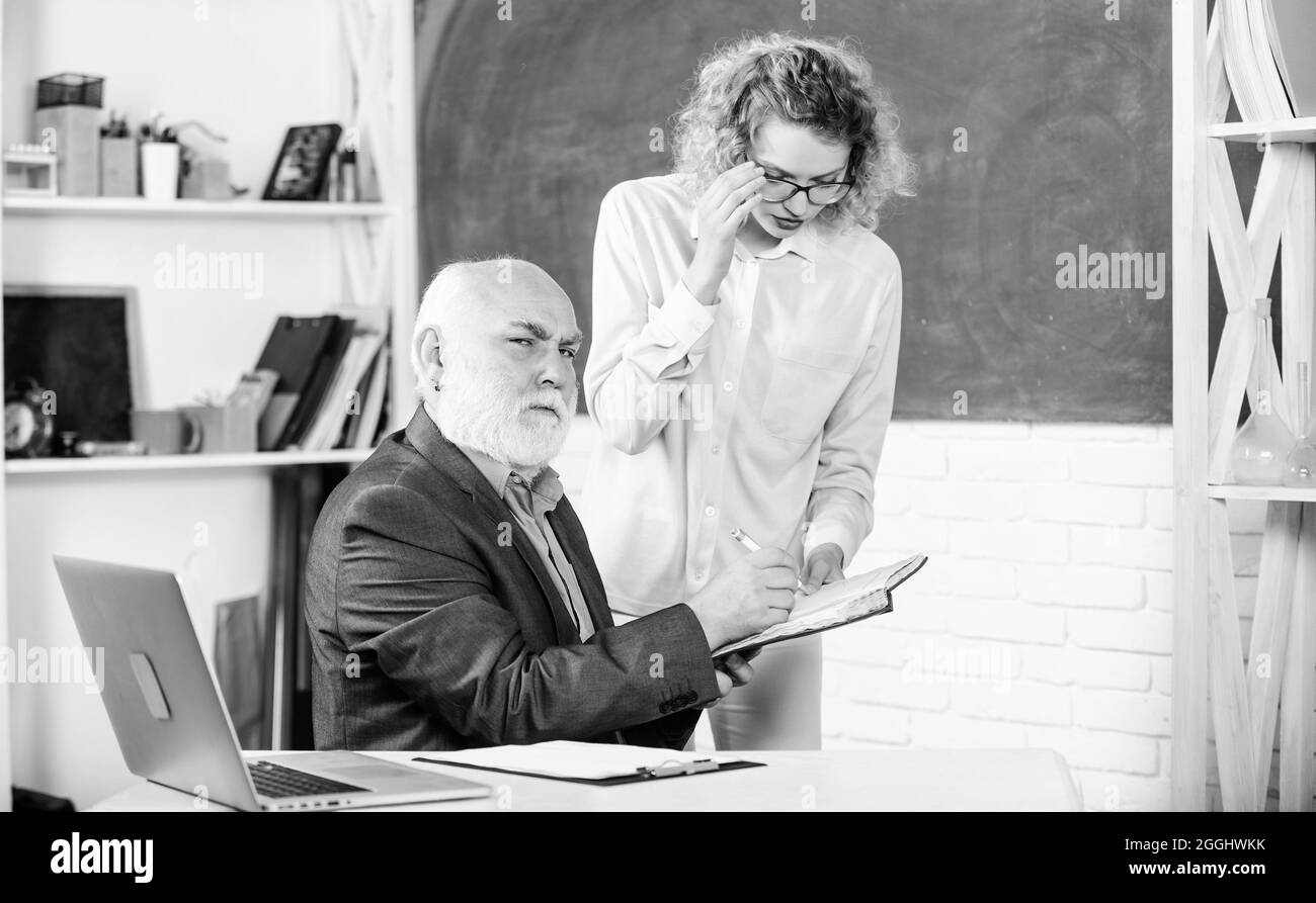 Développement. Examen réussi. Salle des enseignants. Étudiant et tuteur avec ordinateur portable. Obtenir de l'information pour la leçon à l'école. Fille étudiante avec l'homme tuteur à Banque D'Images