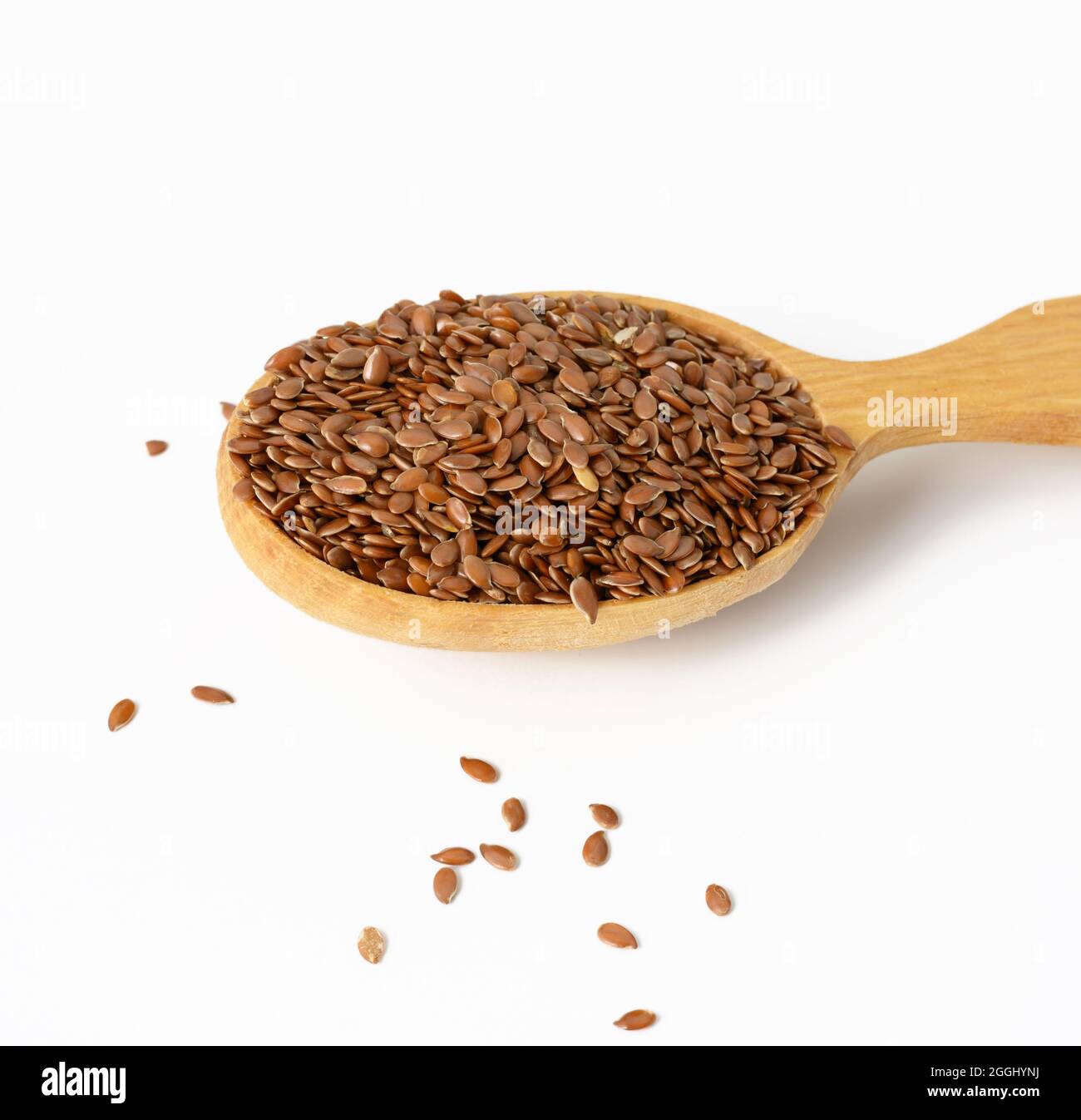 faire dorer les graines de lin sèches dans une cuillère en bois sur fond blanc, vue du dessus Banque D'Images