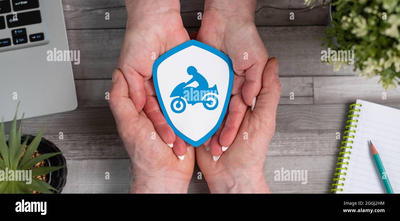 Concept d'assurance moto avec protection en papier entre les mains Photo  Stock - Alamy