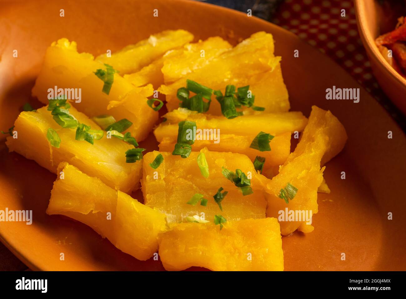 portion de manioc cuit arrosée de ciboulette. Banque D'Images