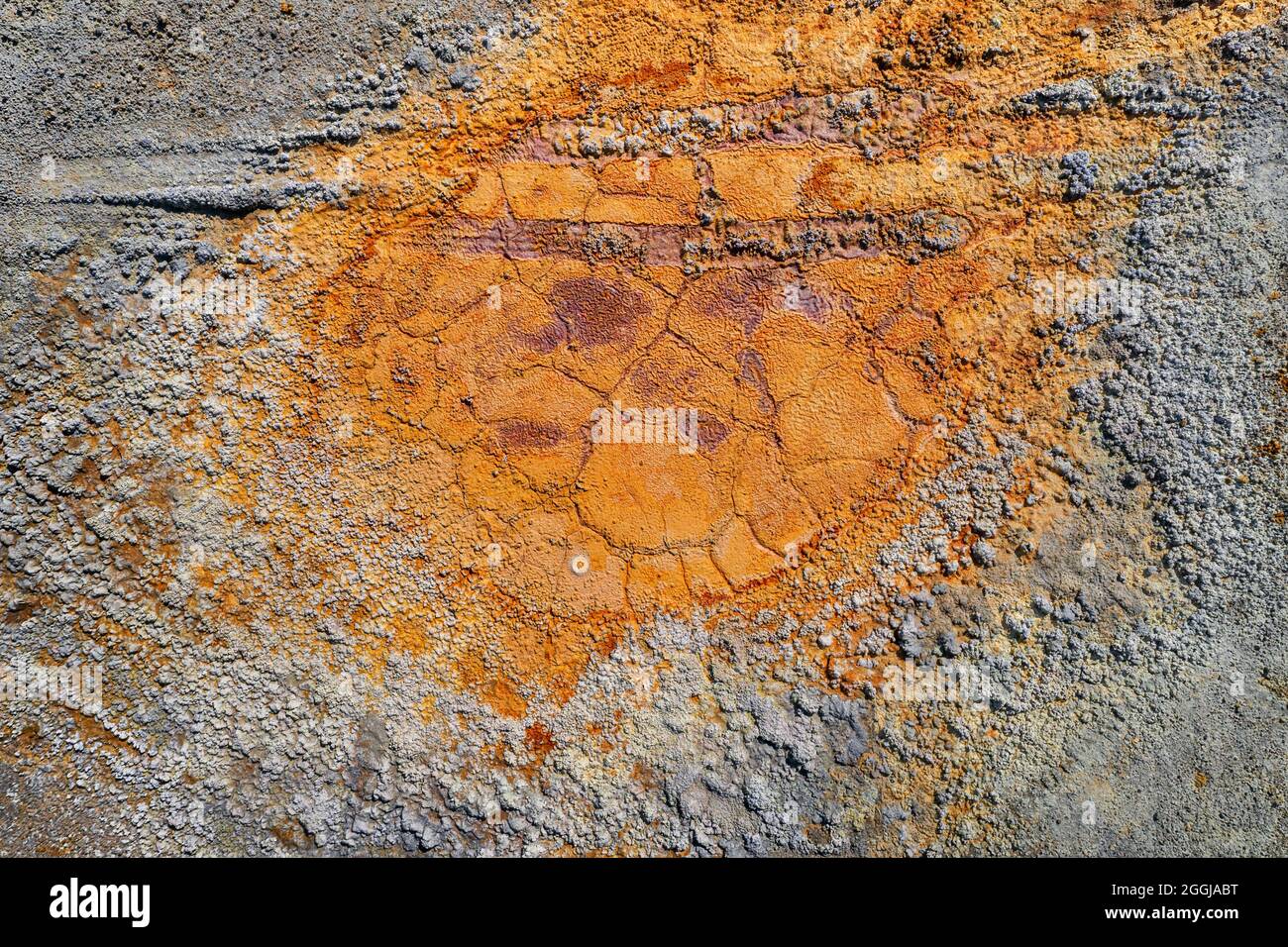 Piscine rouillée sèche avec traces de pneus et texture de terre grise rugueuse contaminée provenant de la mine de pyrite abandonnée Banque D'Images