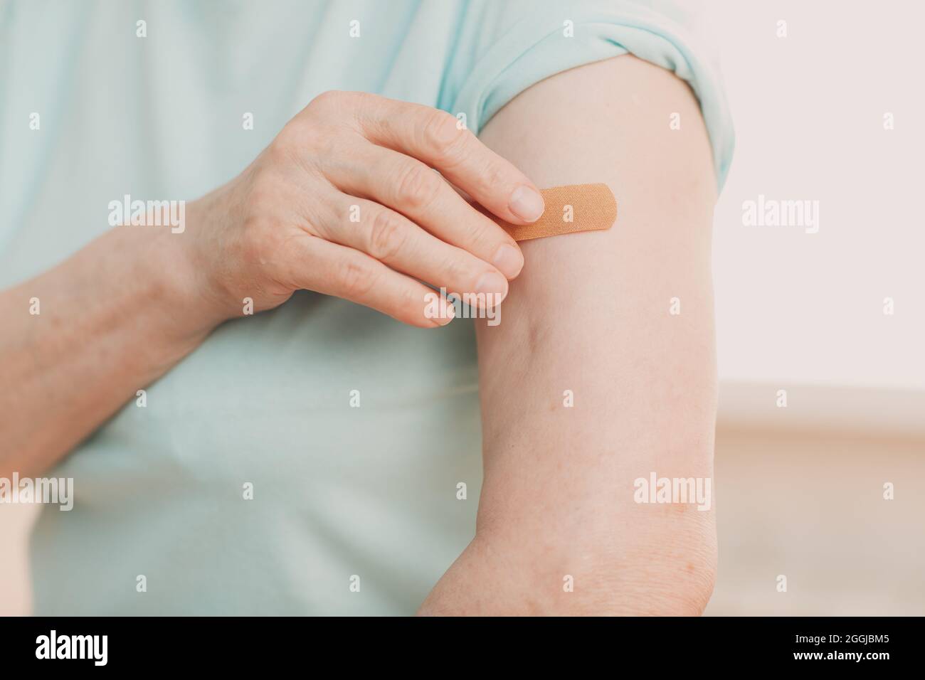 Vaccination une femme âgée dans le bureau du médecin avec le vaccin adhésif Covid-19 plâtre Banque D'Images