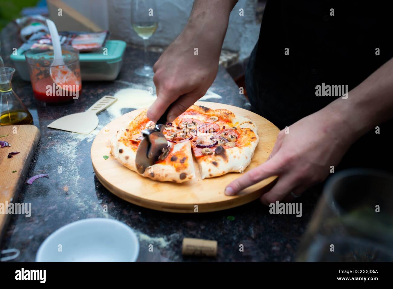 Le père coupe de la pizza pour les enfants Banque D'Images