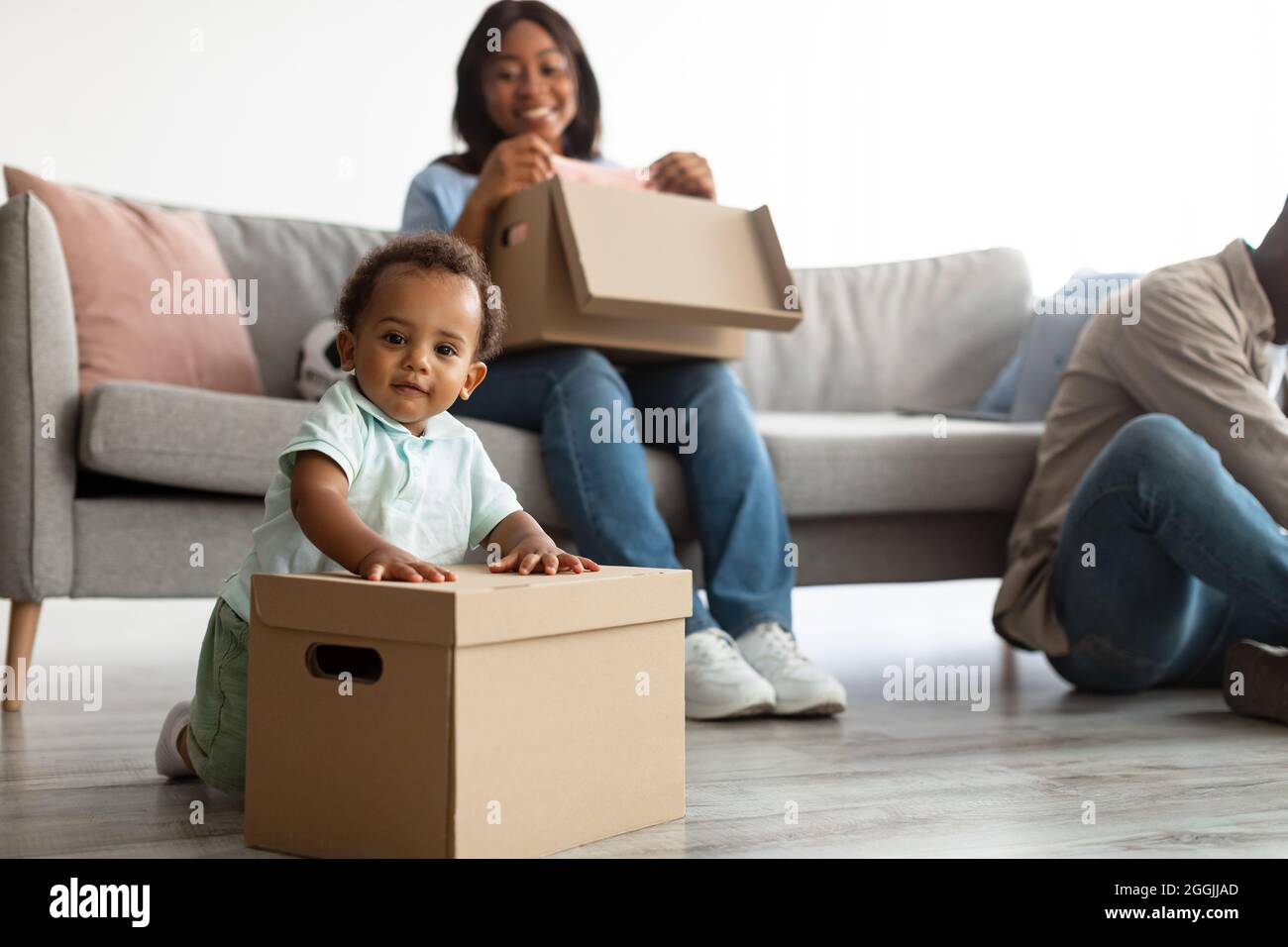 Bonne famille afro-américaine en train de déménager dans un nouvel appartement Banque D'Images