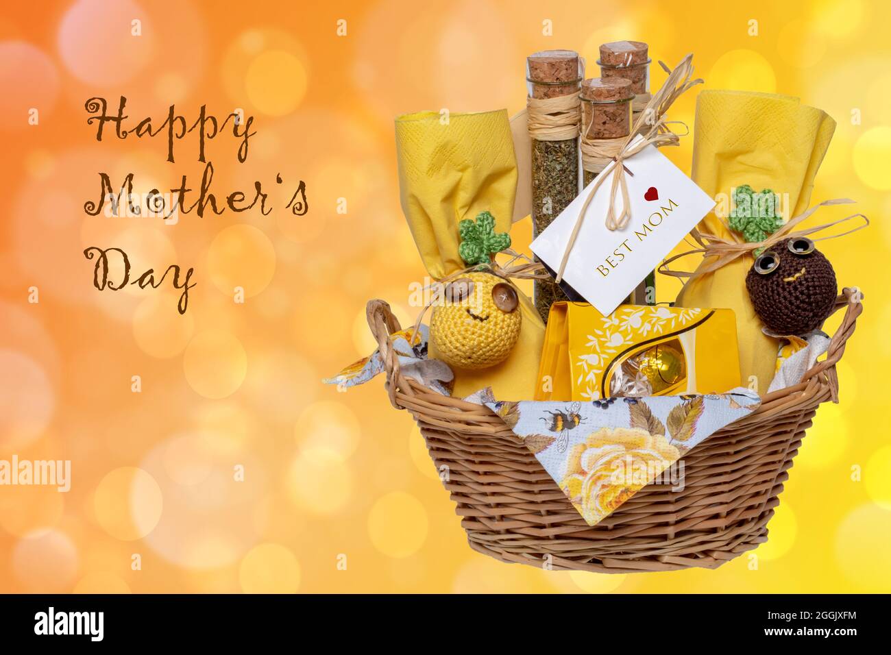 Carte de vœux de fête des mères. Gros plan d'un panier cadeau avec des  mélanges d'épices méditerranéennes avec une étiquette de meilleur maman,  chocolat et autres cadeaux sur le yello abstrait Photo