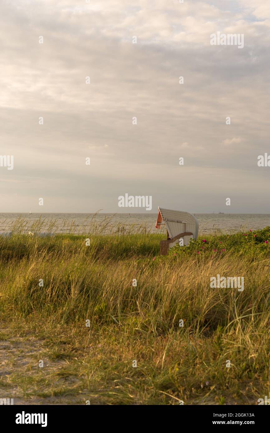 Vacances dans une chaise de plage au soleil sur la mer Baltique, Kiel Fjord à Stein, Allemagne. Banque D'Images