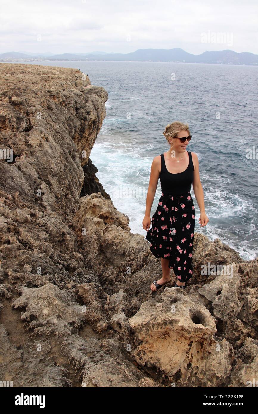 Jeune femme sur la côte rocheuse, plage rocheuse, rochers à Punta de n'Amer, Cala Millor, Majorque, Iles Baléares, Espagne Banque D'Images