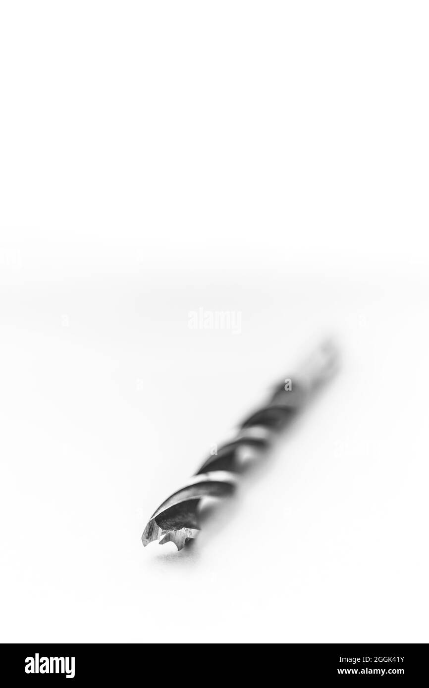 Un portrait en studio noir et blanc d'un foret en acier haute vitesse en métal couché sur fond blanc. L'outil est utilisé par un menuisier pour d Banque D'Images