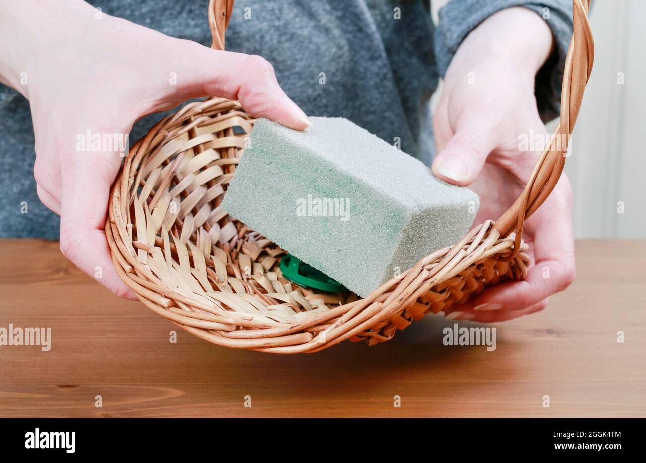 Fleuriste au travail: Comment faire l'arrangement floral d'automne dans le panier en osier utilisant des fleurs séchées et d'autres plantes. Étape par étape, tutoriel. Banque D'Images