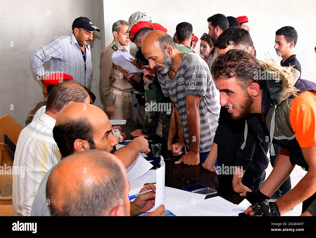 Daraa, Syrie. 1er septembre 2021. Des hommes armés déposent leurs dossiers criminels auprès de la police militaire syrienne dans la province de Daraa, dans le sud de la Syrie, le 1er septembre 2021. Un nouvel accord visant à désamorcer les tensions dans la province de Daraa est entré en vigueur mercredi, à commencer par la capitulation d'un certain nombre de rebelles armés aux autorités syriennes, selon l'agence de presse nationale SANA et un moniteur de guerre. Crédit: Ammar Safarjalani/Xinhua/Alamy Live News Banque D'Images