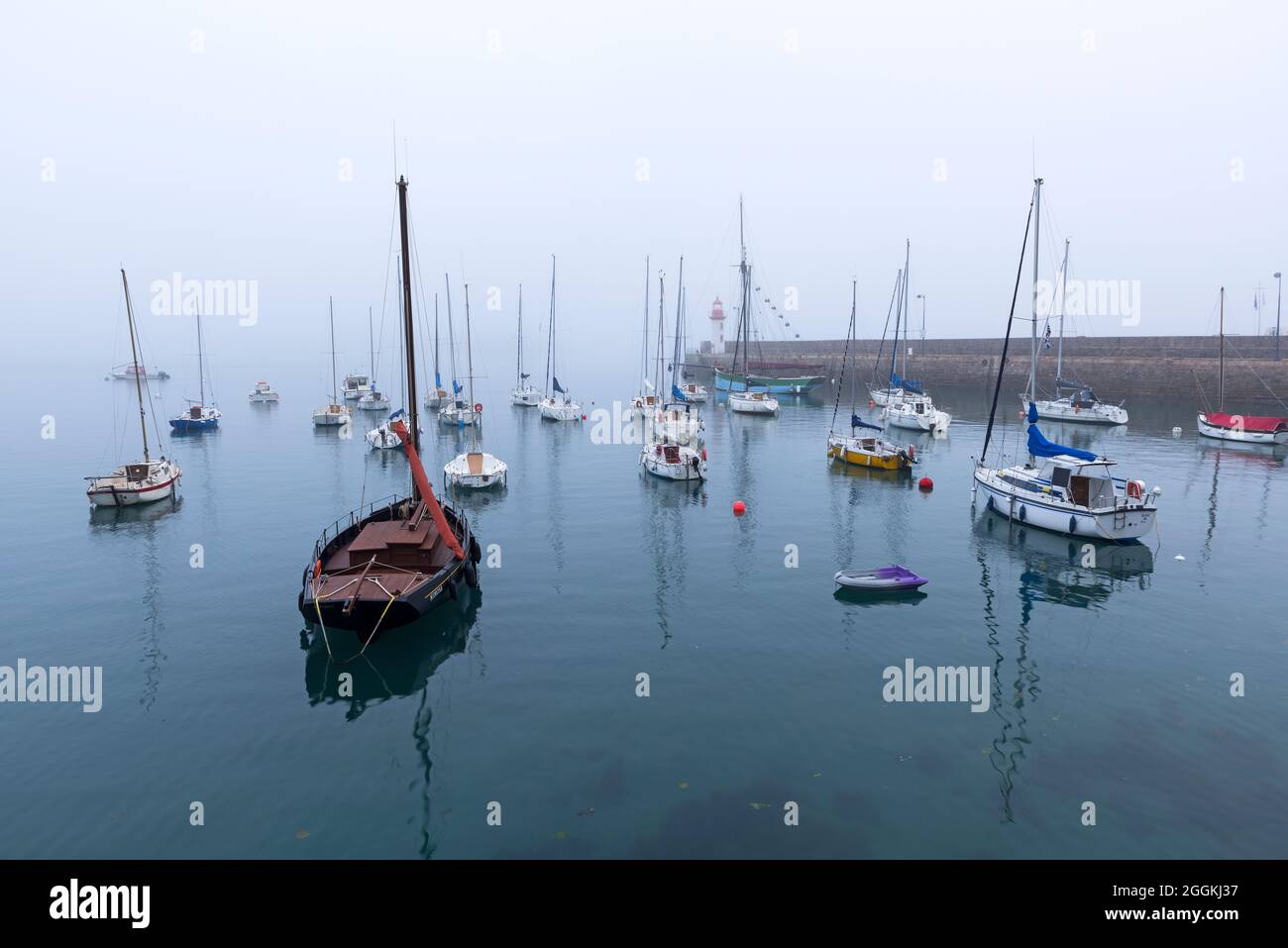 Ambiance brumeuse dans le port d'Erquy, en arrière-plan le petit phare sur la jetée, France, Bretagne, Département Côtes d'Armor, Côte de Penthièvre Banque D'Images