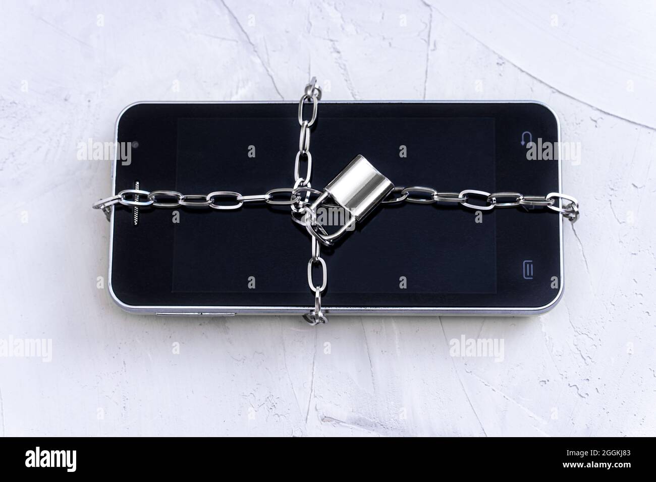 Gros plan d'un smartphone verrouillé par un verrou de chaîne. Concept de confidentialité des données. Banque D'Images