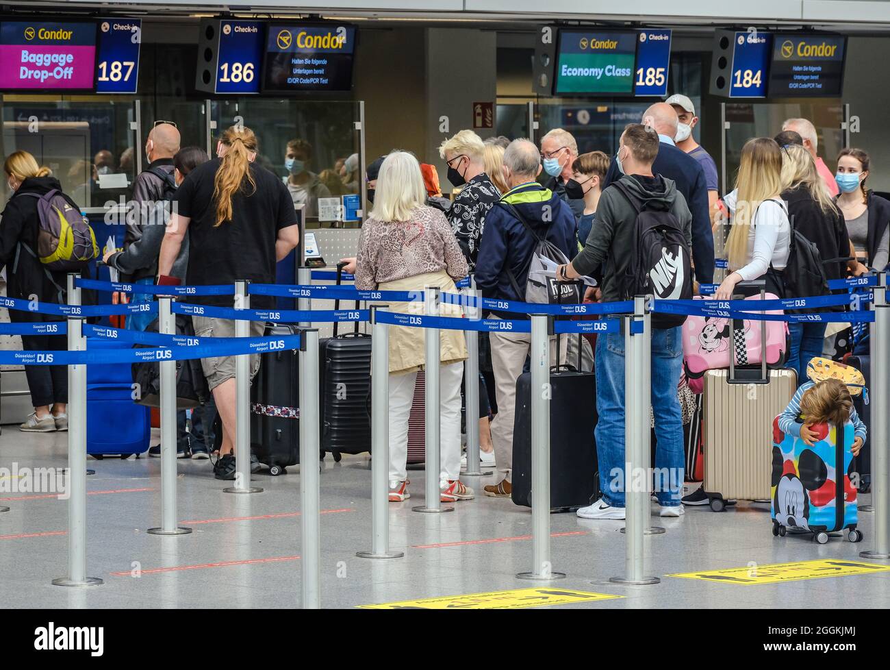 Duesseldorf, Rhénanie-du-Nord-Westphalie, Allemagne - aéroport de Düsseldorf, début de vacances à NRW, les vacanciers sont en ligne avec les valises au comptoir d'enregistrement de Condor en temps de pandémie de corona sur leur chemin vers les vacances d'été, les vacanciers devraient avoir un test PCR, ID / code QR garder prêt. Banque D'Images