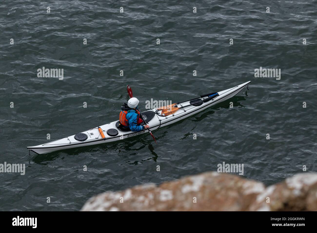 Un kayakiste vu des falaises près d'Aberdour, Fife, Écosse. Banque D'Images
