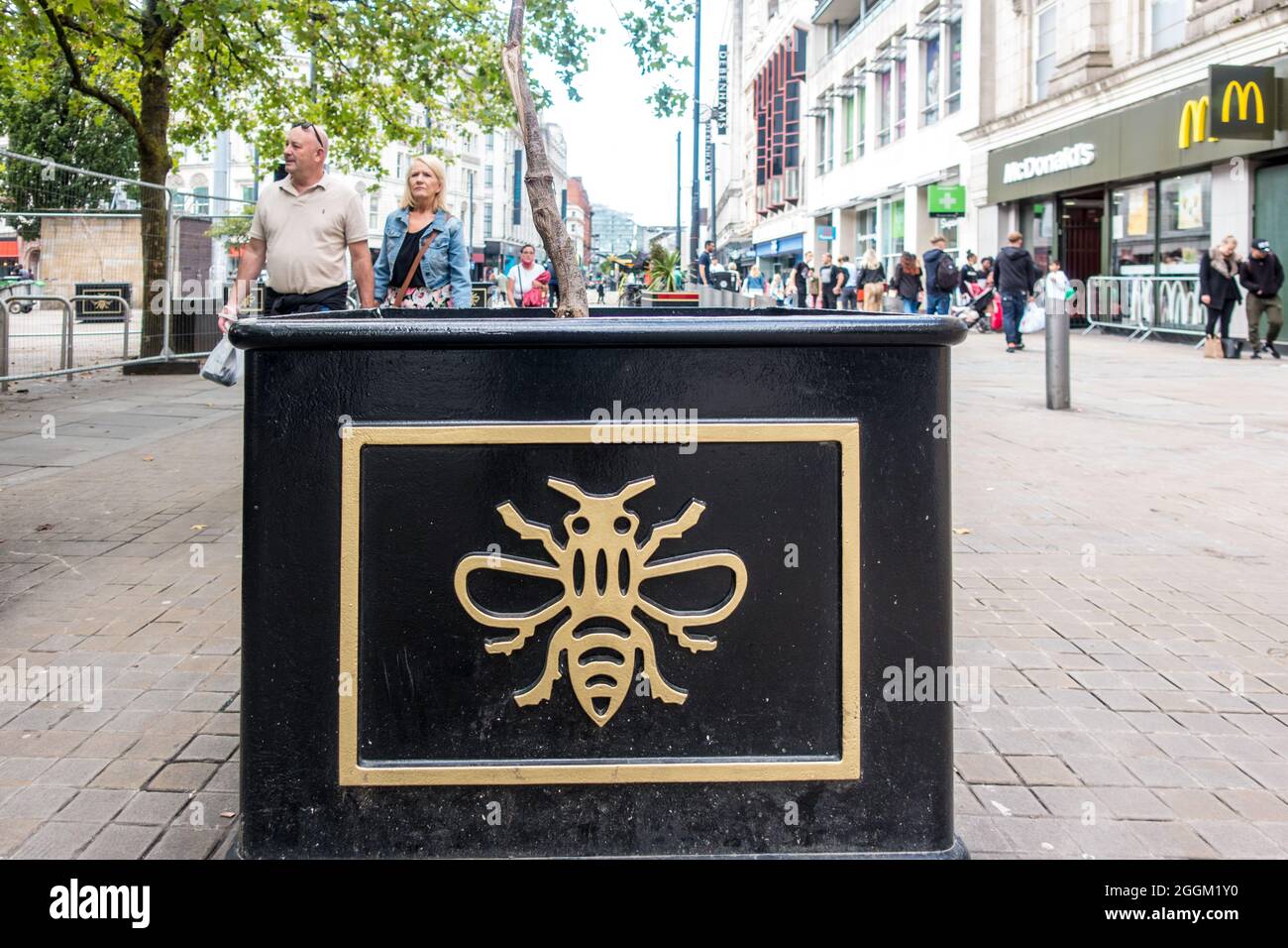 Symbole Manchester Bee sur les planteurs de route placés à l'entrée de la rue haute dans le centre de Manchester City Banque D'Images