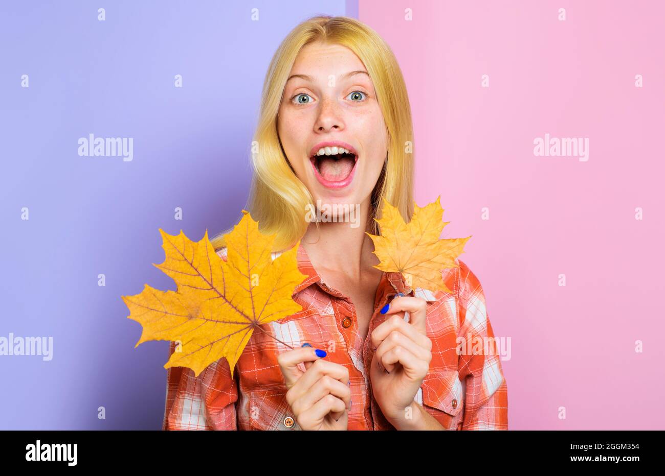 Blonde fille en tenue décontractée avec feuille dorée. Ambiance d'automne. Femme souriante aux feuilles jaunes. Tendances de la mode pour l'automne. Banque D'Images