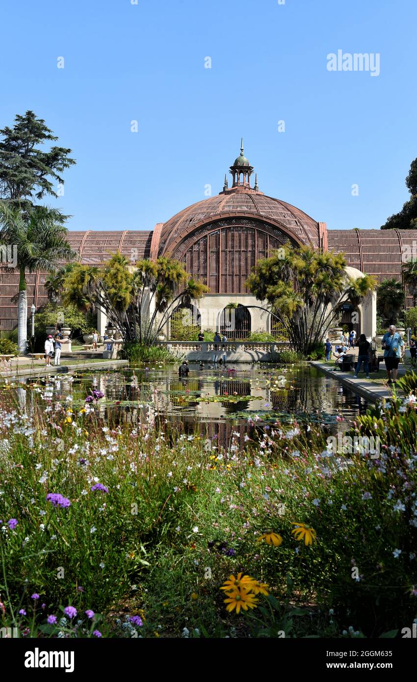 SAN DIEGO, CALIFORNIE - 25 AOÛT 2021 : le bâtiment botanique du parc Balboa avec fleurs et Lily Pond en premier plan. Banque D'Images