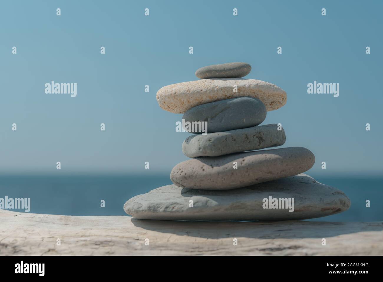 Pierres de pyramide sur le bord de mer lors d'une journée ensoleillée sur le fond bleu de la mer. Joyeuses vacances. Plage de galets, mer calme, destination de voyage. Concept de heureux Banque D'Images