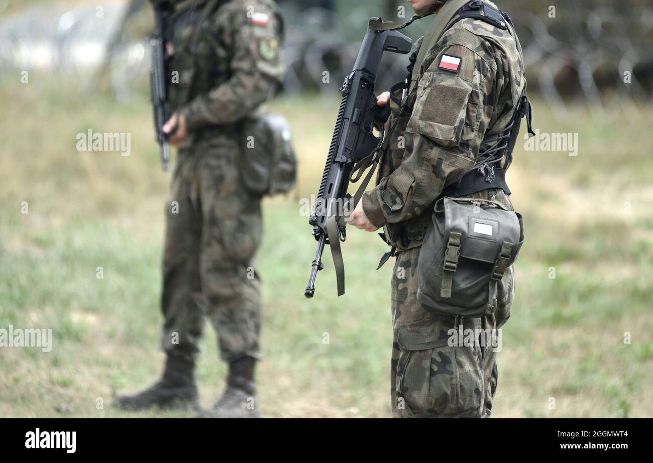 Soldats de la Pologne avec fusil d'assaut et drapeau de la Pologne sur l'uniforme militaire. Soldats polonais avec fusil d'assaut. Banque D'Images