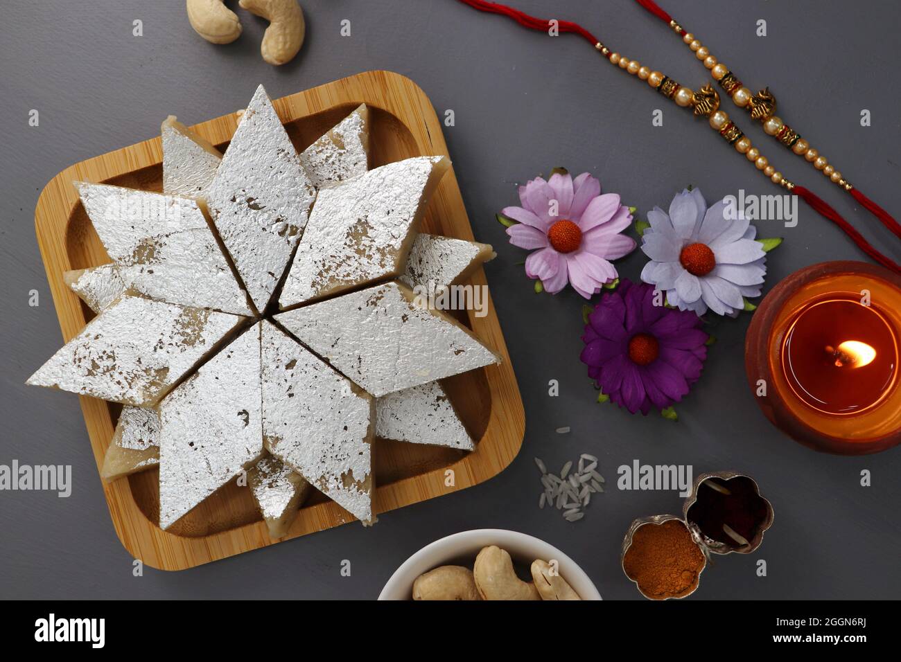 Festival indien Raksha bandhan. Rakhi thali avec diya, fleurs et tilak avec des sucreries assorties telles que Gulab Jamun, Kaju katli, et Churma Laddo. Banque D'Images Festival indien Raksha bandhan. Rakhi thali avec diya, fleurs et tilak avec des sucreries assorties telles que Gulab Jamun, Kaju katli, et Churma Laddo. Banque D'Images