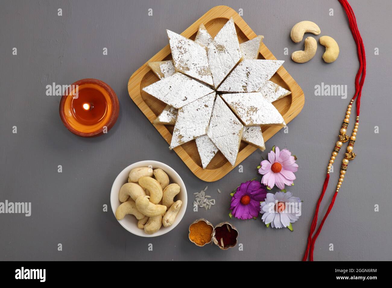 Festival indien Raksha bandhan. Rakhi thali avec diya, fleurs et tilak avec des sucreries assorties telles que Gulab Jamun, Kaju katli, et Churma Laddo. Banque D'Images Festival indien Raksha bandhan. Rakhi thali avec diya, fleurs et tilak avec des sucreries assorties telles que Gulab Jamun, Kaju katli, et Churma Laddo. Banque D'Images