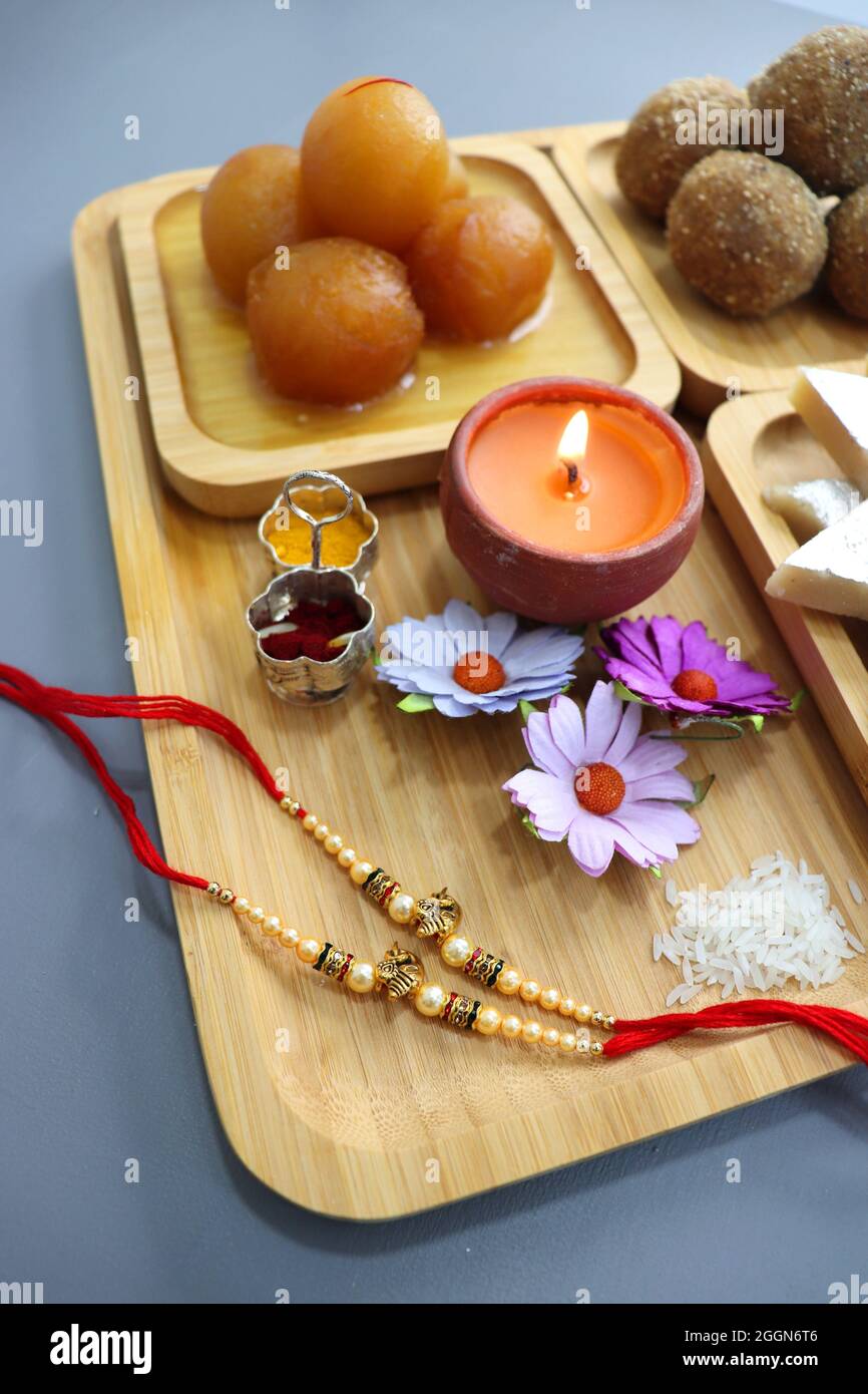 Festival indien Raksha bandhan. Rakhi thali avec diya, fleurs et tilak avec des sucreries assorties telles que Gulab Jamun, Kaju katli, et Churma Laddo. Banque D'Images Festival indien Raksha bandhan. Rakhi thali avec diya, fleurs et tilak avec des sucreries assorties telles que Gulab Jamun, Kaju katli, et Churma Laddo. Banque D'Images