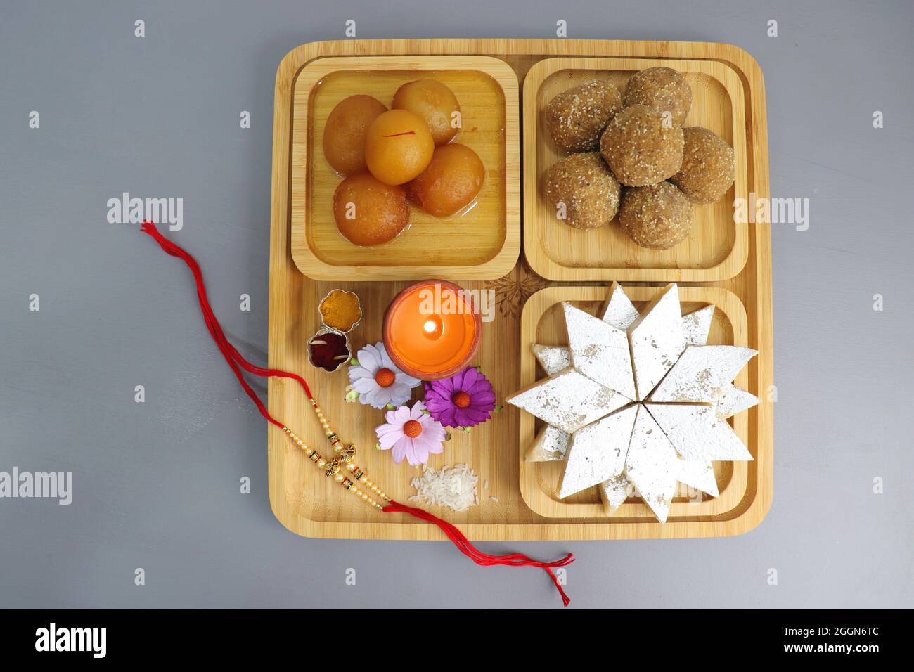 Festival indien Raksha bandhan. Rakhi thali avec diya, fleurs et tilak avec des sucreries assorties telles que Gulab Jamun, Kaju katli, et Churma Laddo. Banque D'Images Festival indien Raksha bandhan. Rakhi thali avec diya, fleurs et tilak avec des sucreries assorties telles que Gulab Jamun, Kaju katli, et Churma Laddo. Banque D'Images