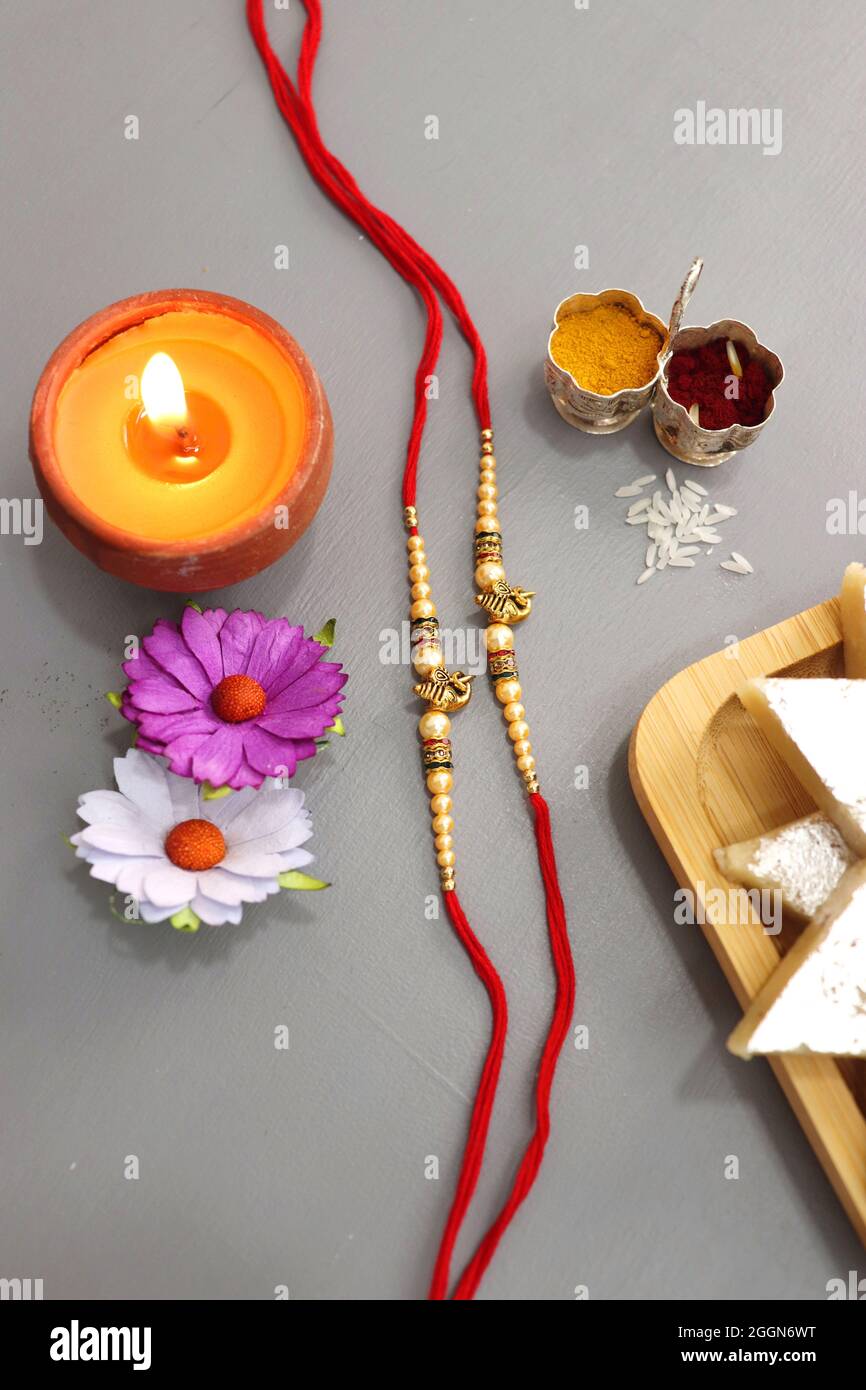 Festival indien Raksha bandhan. Rakhi thali avec diya, fleurs et tilak avec des sucreries assorties telles que Gulab Jamun, Kaju katli, et Churma Laddo. Banque D'Images Festival indien Raksha bandhan. Rakhi thali avec diya, fleurs et tilak avec des sucreries assorties telles que Gulab Jamun, Kaju katli, et Churma Laddo. Banque D'Images