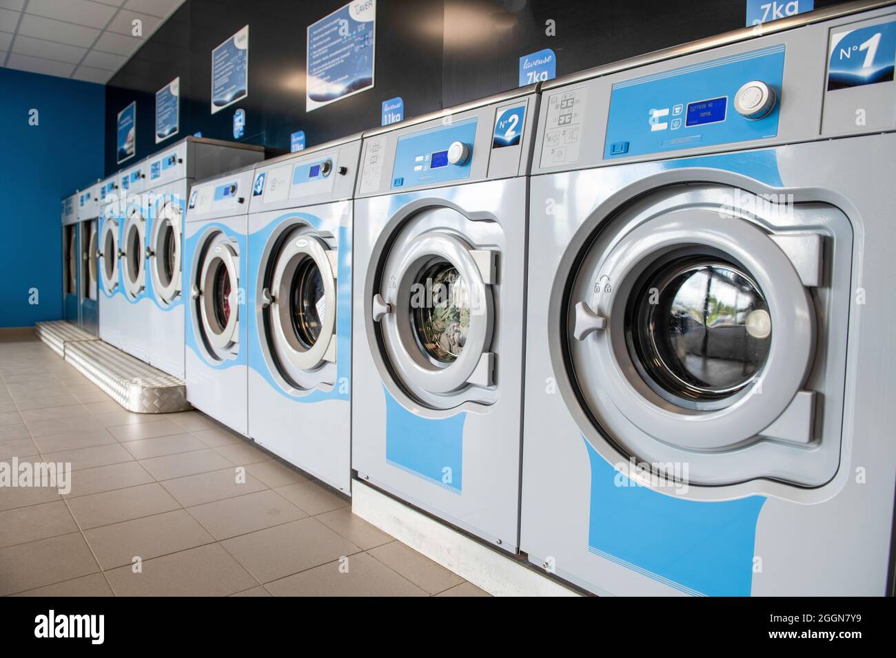 Rangée de lave-linge de blanchisserie dans le magasin public. Banque D'Images