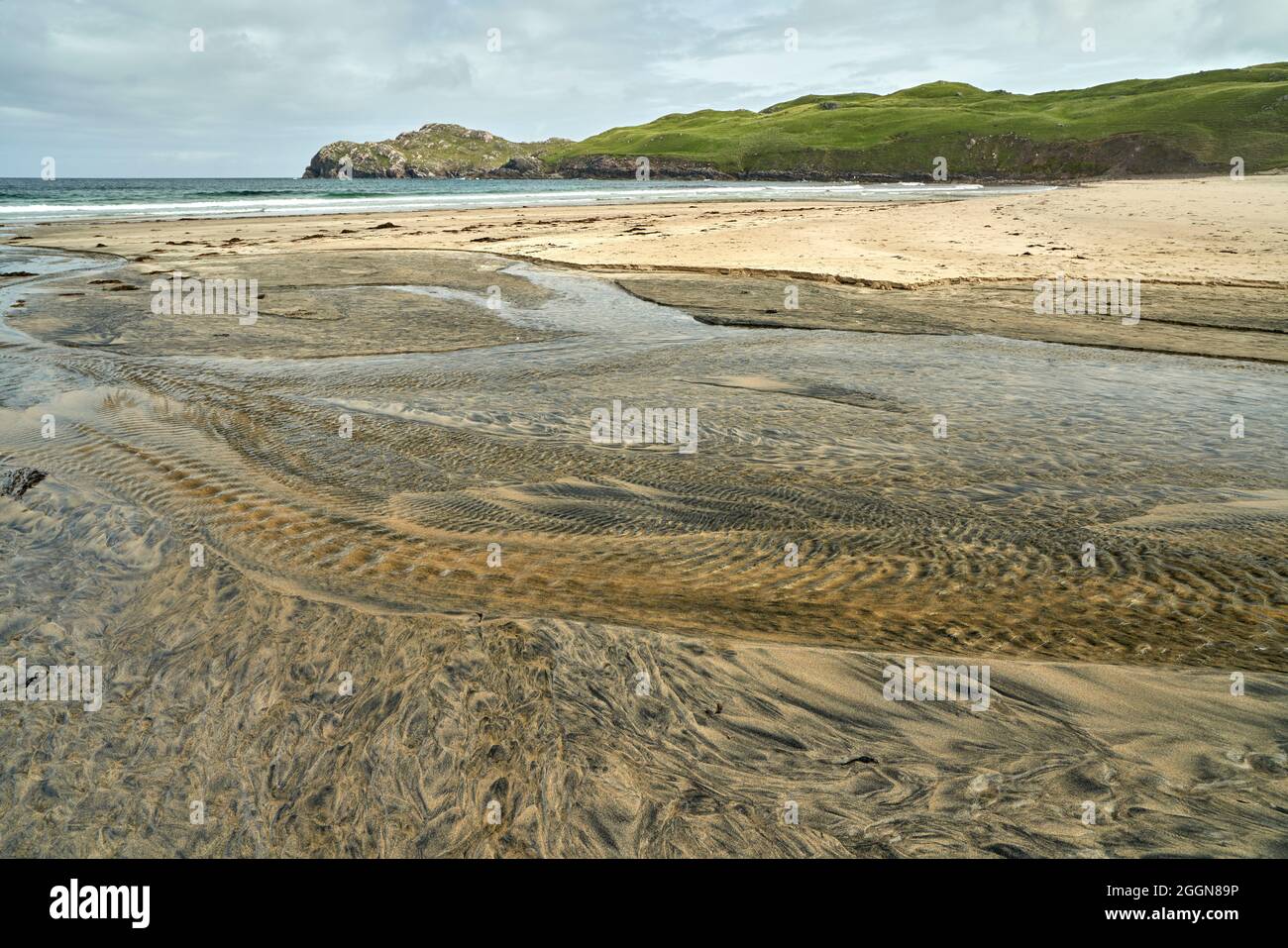 Détails fluviaux sur une plage où la tourbe est lavée dans le sable et la marée crée de beaux motifs. Reef Beach dans l'île de Lewis. Banque D'Images
